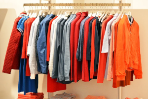 室内用物干しにかかったオレンジや赤色の服