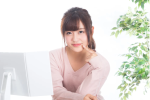 顎に指をあてながらにっこりしている女性
