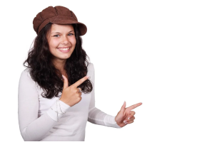 帽子をかぶった外国人の女性が、両手の親指と人差し指を伸ばして何かを指している様子