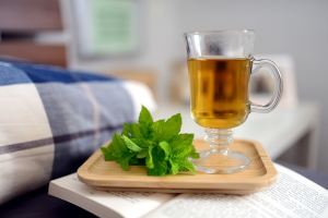 木のおぼんにハーブとお茶が入ったグラス
