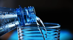 ペットボトルの水をコップに注いでいる