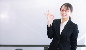 赤い眼鏡をかけた女性が指でOKとしている