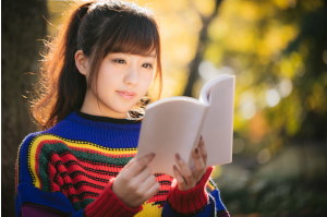 外で本をん読んでいる女性