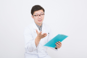 白衣を着た男性がカルテを持って訪ねている