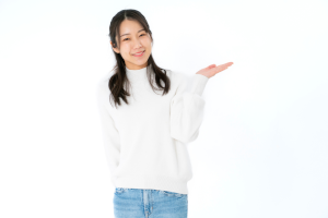白い服を着た髪の長い女性が左手でどうぞとしている