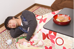 こたつに入ったまま寝てしまった男性