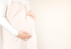 妊娠中の女性がお腹に手をあてている