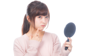丸い手が鏡を持った女性が顎に指を当てて悩んでいる