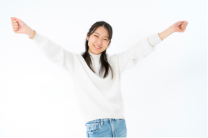 白い服を傷女性が両手を上げて喜んでいる