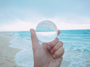 海をバックに水晶玉を持っている手