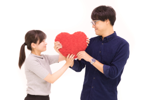 ハートのぬいぐるみを持っているカップル