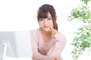 鏡を置いて顎に人差し指をあてている女性