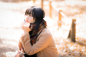 マフラーをつけた女性がかがんでいる