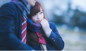 1枚のマフラーを彼氏と一緒に使っている女子高生