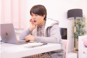 座ってパソコンを見ている男性