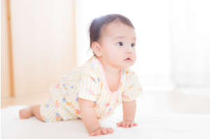 ハイハイしている赤ちゃんがどこかを見つめている
