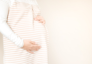 妊娠中の女性がお腹に手をあてている
