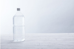 白い壁･白い床に置かれた水の入ったペットボトル