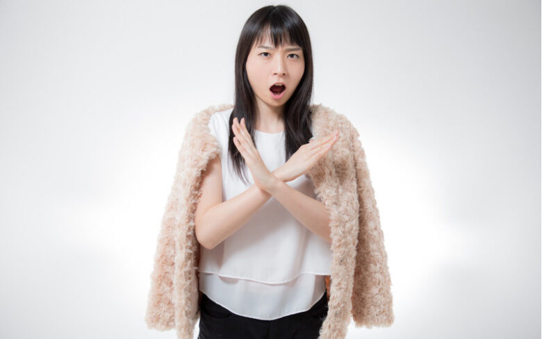 腕をクロスして大きな×ポーズをする女性