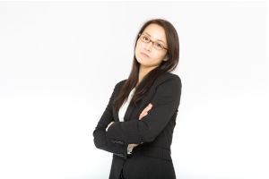 スーツの女性が不服そうな顔でこっちを見ている