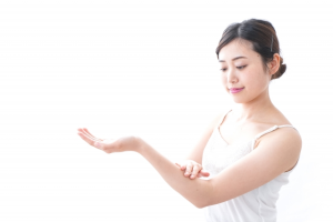 左腕に日焼け止めを塗る女性