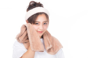 顔にタオルをあてている女性
