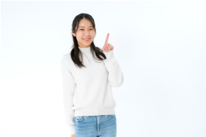 白い服を着た女性が人差し指を立てている