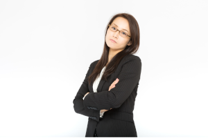 腕を組んで困っている表情のスーツの女性