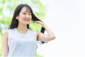 黒い長い髪を触っている女性