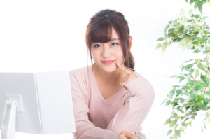 顎に指をあててこっちを見ている女性
