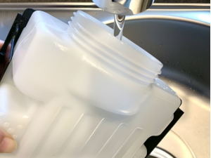 加湿器のタンクに水を入れている