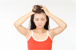 髪の毛をぐしゃぐしゃにしている赤いキャミソールを着た女性