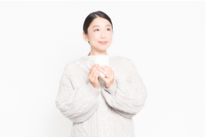左斜め上を見ているコップを持った女性