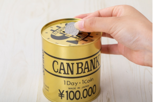 貯金箱に100円玉を入れる様子