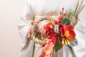 正月飾りを持った着物の女性