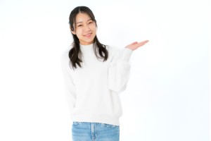 白い服を着た女性が左手でどうぞとしている