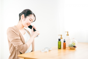 ヘアオイルを塗っている座っている女性