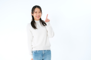 白い服を着た女性が人差し指を立てている