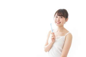 歯ブラシを持ったキャミソールの女性