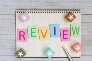 ノートの上にREVIEWと書かれた長方形の色とりどりの積木