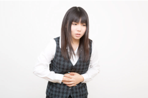お腹をおさえている女性