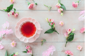 紅茶がカップの周りに花がたくさん置かれている