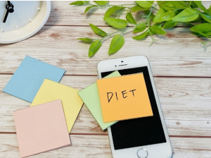 青色･ピンク･黄色･黄緑色の付箋とスマホの上に乗ったDIETと書かれたオレンジ色の付箋