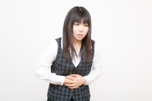 お腹をおさえている女性