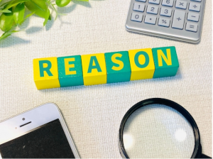 REASONと1文字ずつ書かれた積み木の周りに電卓･虫眼鏡･スマホ
