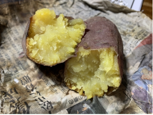 新聞紙の上に置かれた半分に割った焼き芋