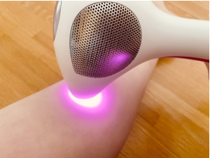 ピンクの光を発している脱毛器