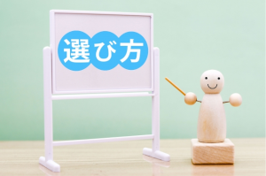 選び方と書かれた小さなホワイトボードと木で出来た人間