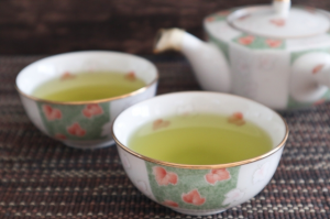 急須とお茶の入った湯飲み茶わんが2つ