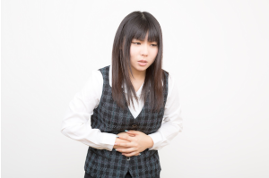 お腹をおさえている女性